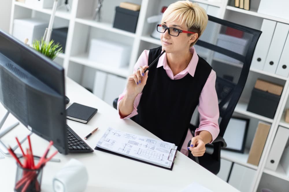 Une jeune fille est assise à un bureau dans le bureau