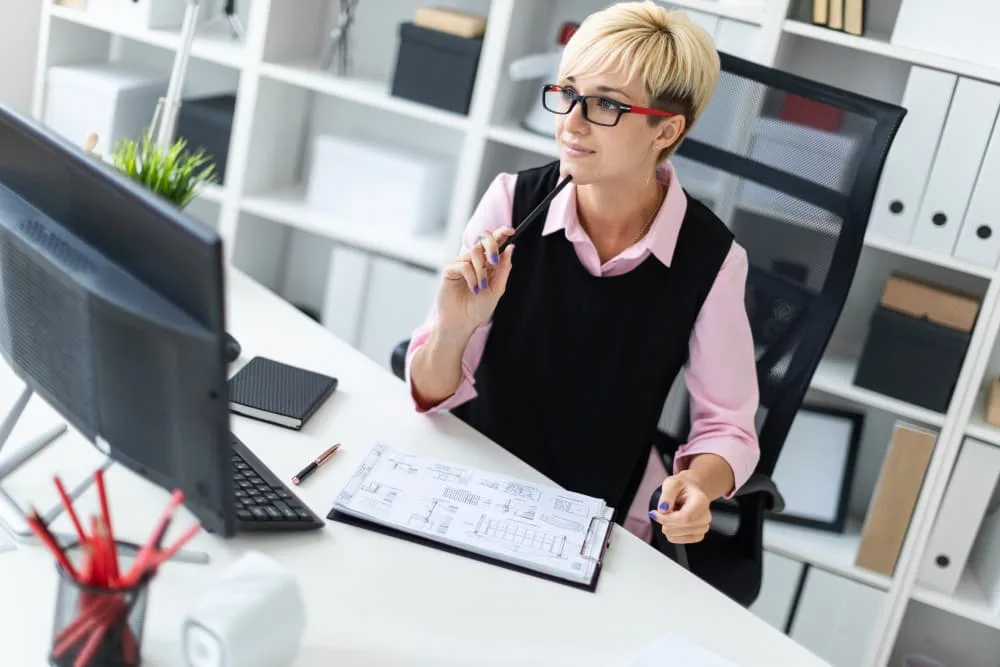 Une jeune fille est assise à un bureau dans le bureau