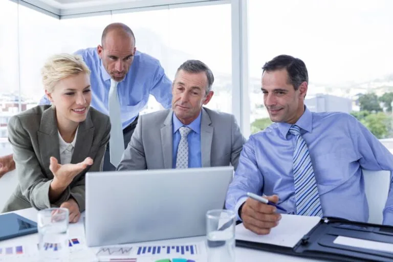 Equipe finance travaillant ensemble sur ordinateur portable