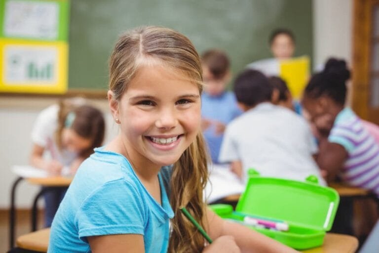 Élève souriant à la caméra dans la salle de classe