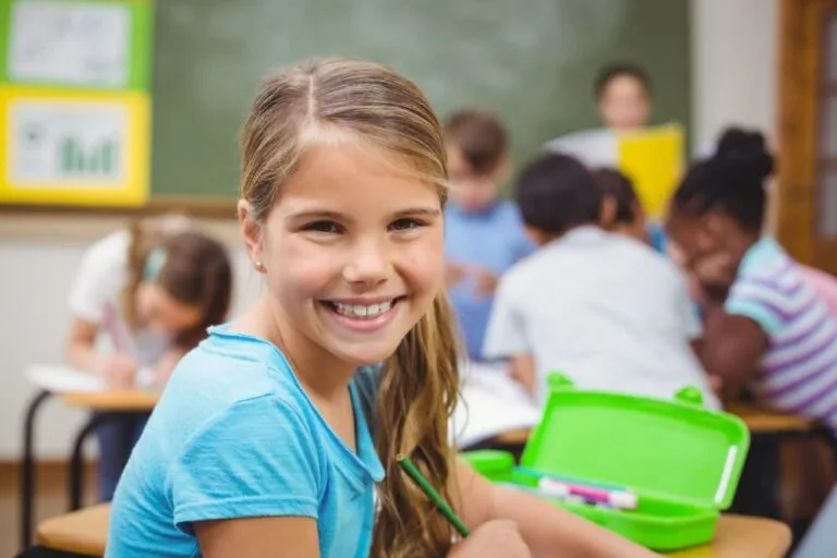 Élève souriant à la caméra dans la salle de classe
