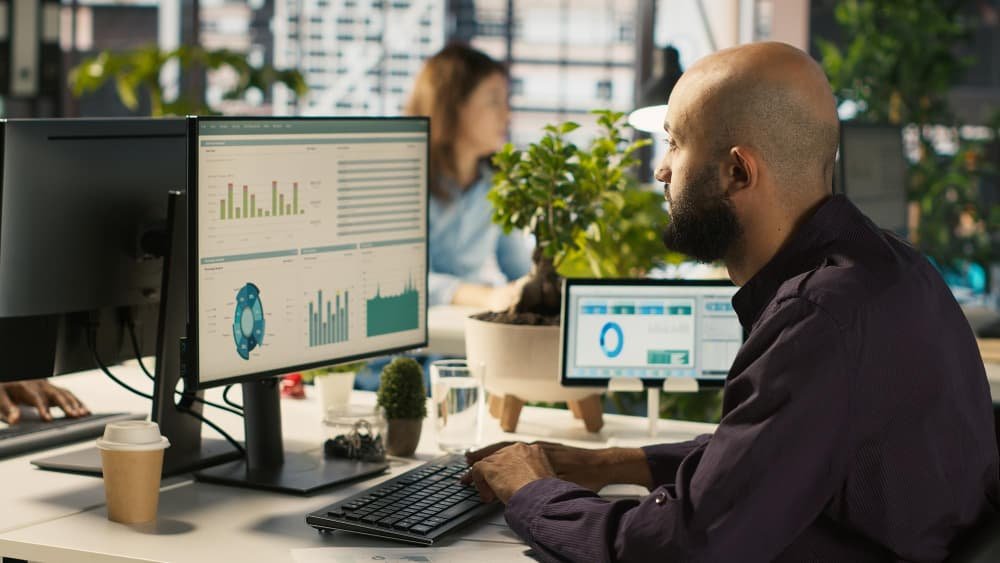 Employé modifiant des documents sur un ordinateur de bureau