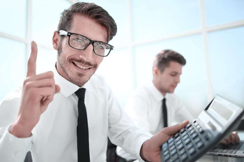 Jeune comptable tenant un pouce vers le haut et souriant