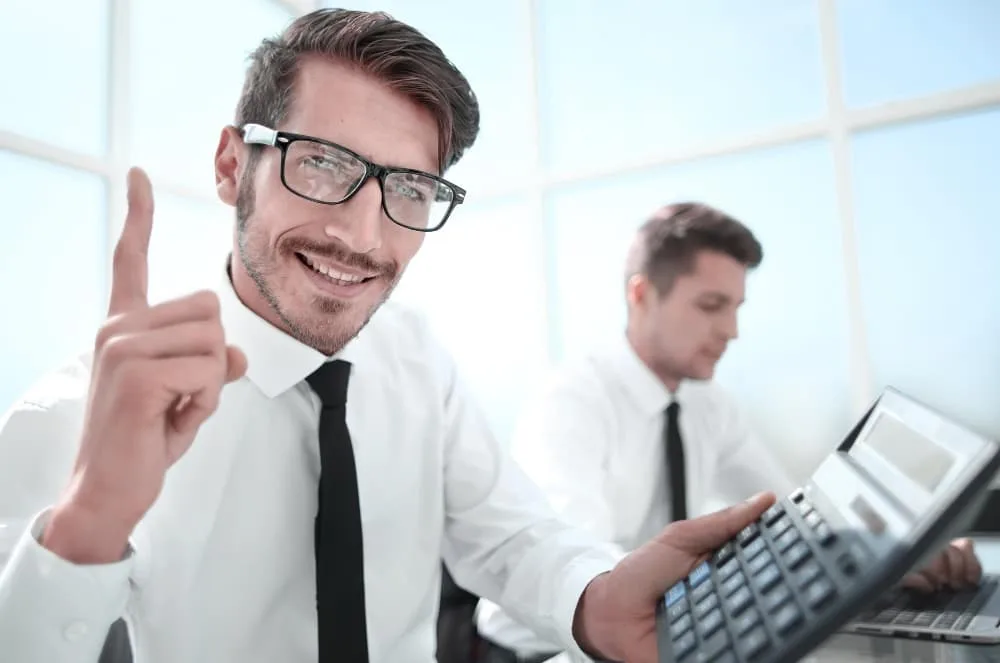 Jeune comptable tenant un pouce vers le haut et souriant